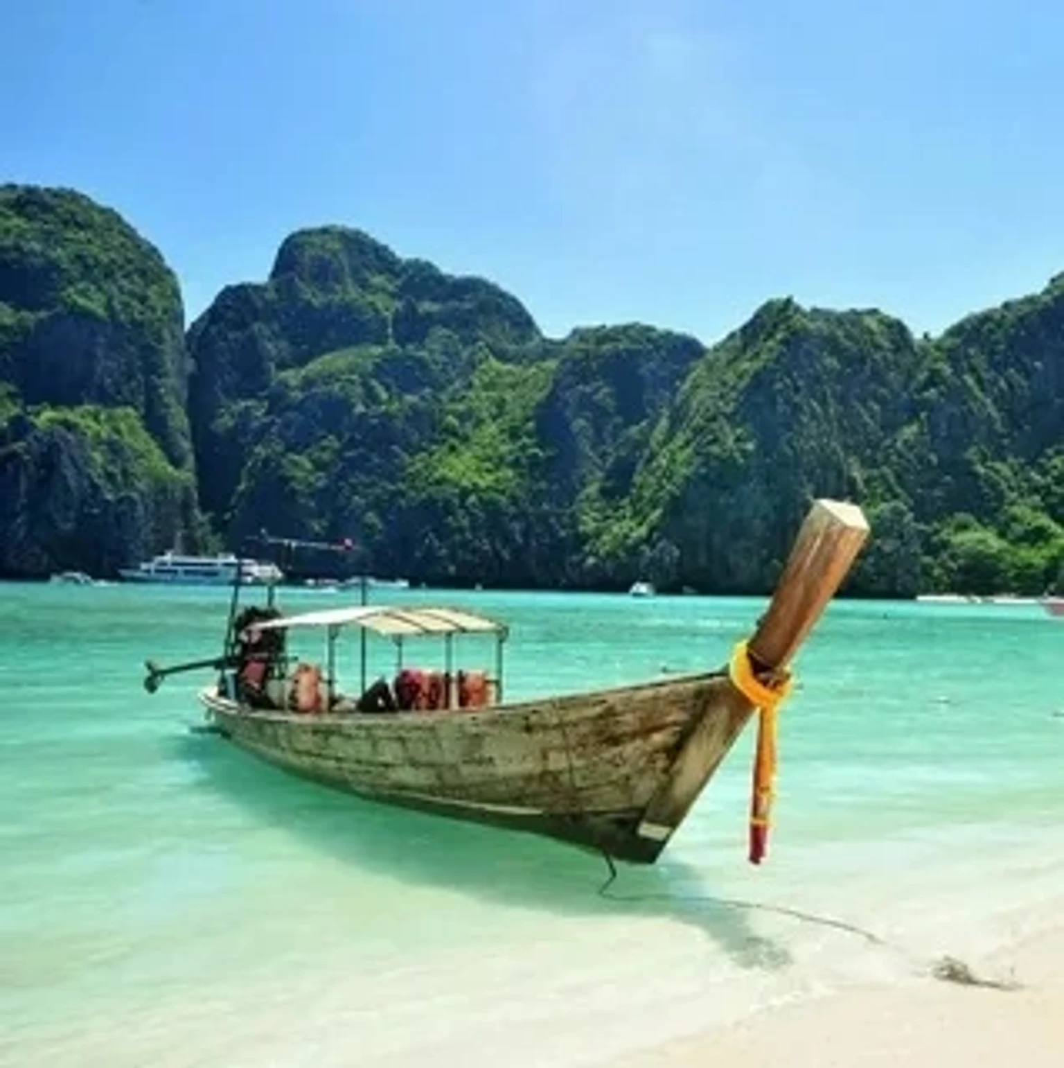 Tropical beach with luxurious holiday packages in Thailand featuring clear waters and palm trees.