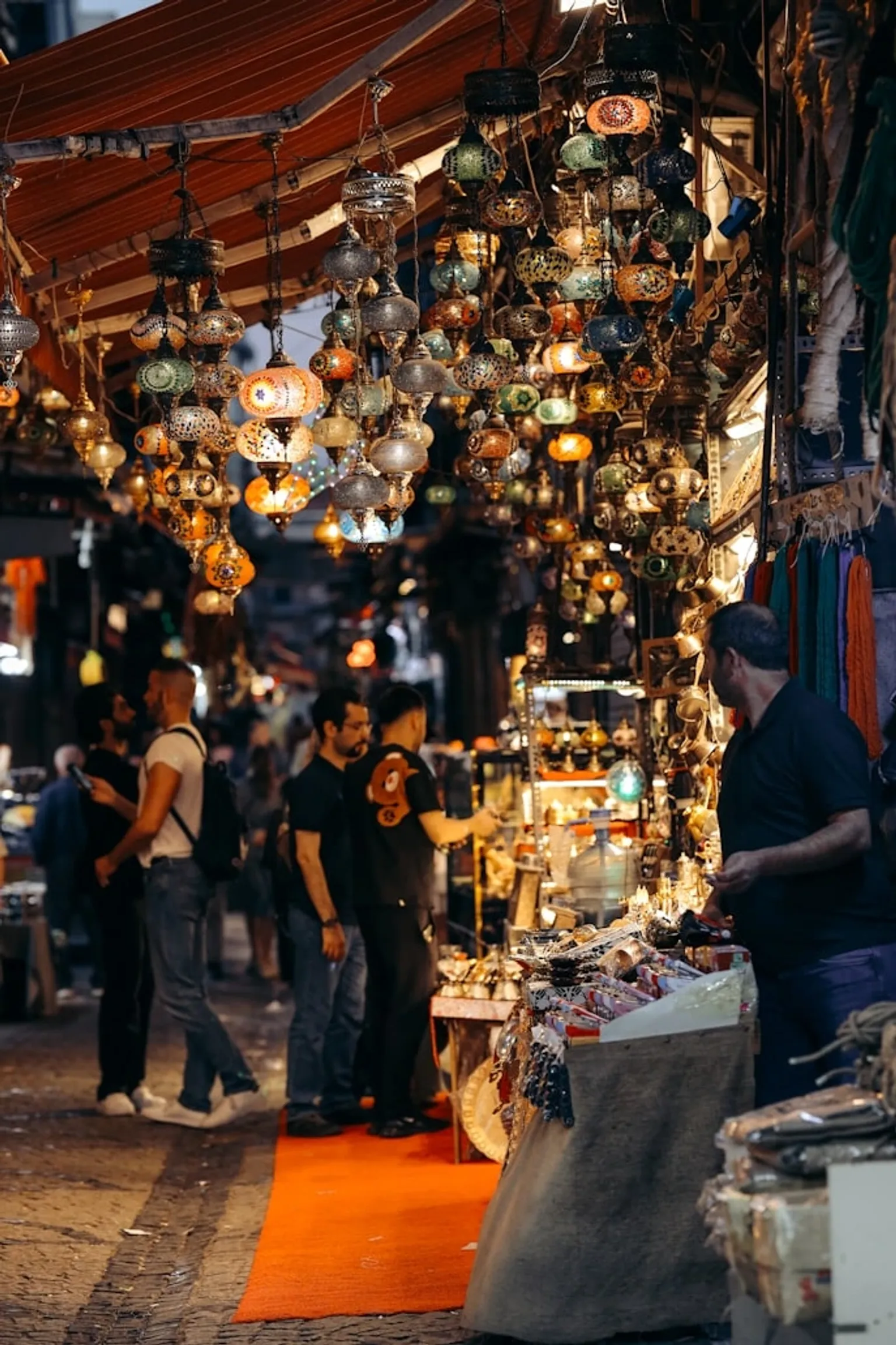 A vibrant market scene featuring an array of colorful products and enthusiastic shoppers exploring various stalls.
